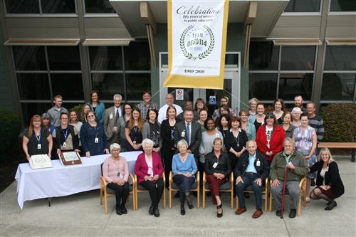 OESD Board of Directors, Superintendent, and Staff Gathered for a Photo on September 20, 2018, with celebration banner &amp; cake
