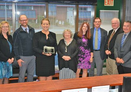 Teacher of the Year Karen Doran holding her award plaque.  Pictured with Board Members, Principal, PA Supt, OESD Supt